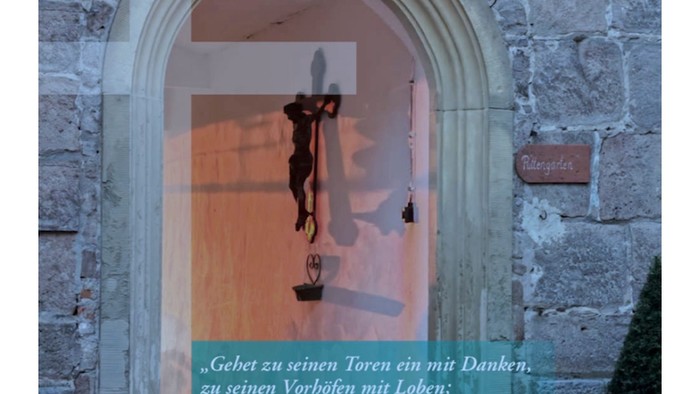 Ein Kruzifix im Türrahmen mit einem Zitat in deutscher Sprache.