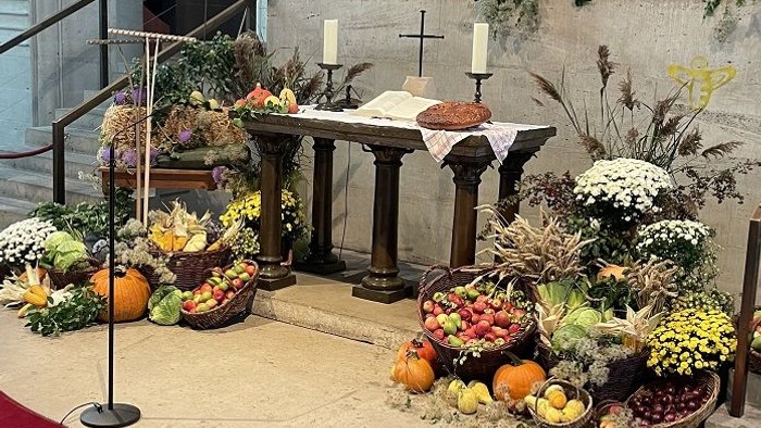 Prachtvolle Kirchendekoration mit Blumen, Kürbissen und Kerzen