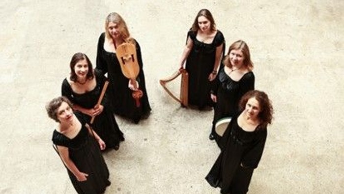 Eine Gruppe von sechs Frauen in schwarzen Kleidern spielt verschiedene Streichinstrumente.