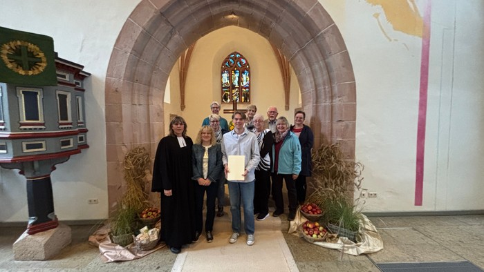 Eine Gruppe von Menschen posiert vor einem Kirchenportal