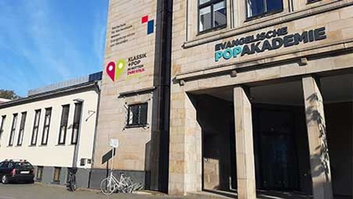 Fassade der Hochschule mit Logo der Hochschule, der Popakademie und der Evang. Kirche von Westfalen