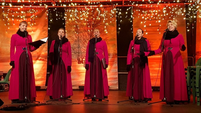 Vier Frauen in roten Kleidern singen auf Bühne