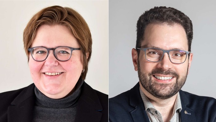 Zwei Personen mit Brillen lächeln in die Kamera