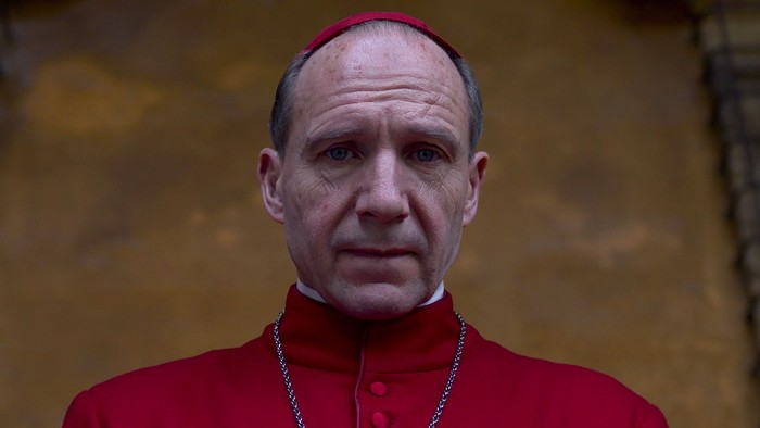 Schauspieler Ralph Fiennes, hier im dunkelroten Talar, spielt in „Konklave“ den Kardinal, der die Vorbereitungen zur Wahl eines neuen Papstes leitet. Foto: © Leonine