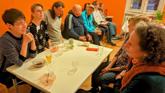 Eine Gruppe von Menschen sitzt an einem Tisch und isst gemeinsam.