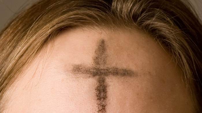 Ein Kreuz aus Asche auf der Stirn einer Person