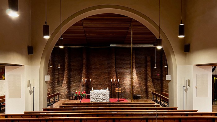 Die Kirche mit hölzernen Bänken und einem Altar im Vordergrund