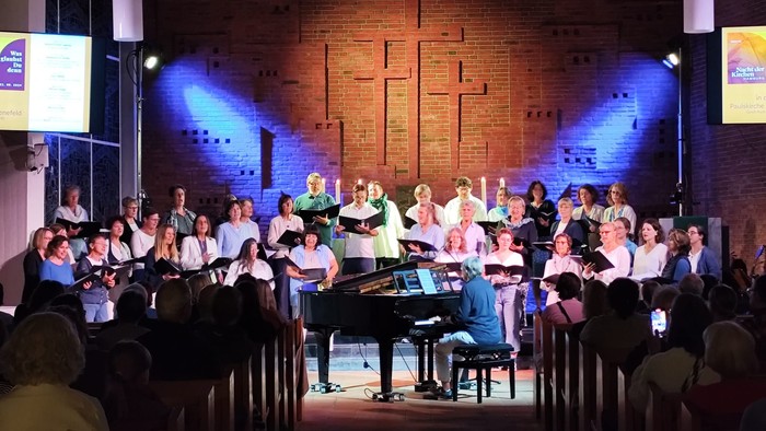 Ein Chor singt auf einer Bühne vor einem Publikum