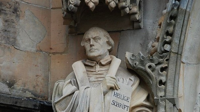 Steinfigur eines Mannes mit Buch, eingraviert