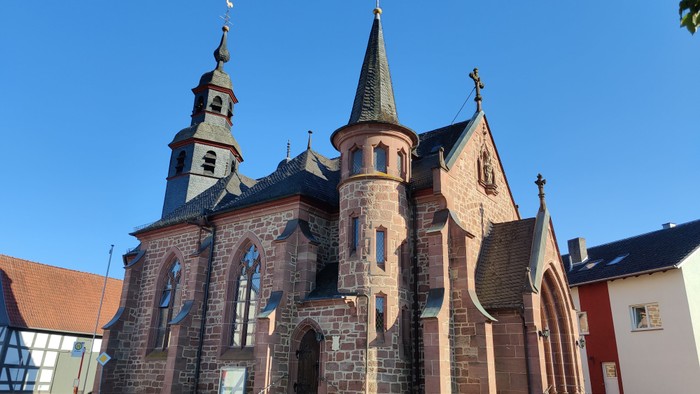 Die Kirche hat zwei Türme und ein spitzes Dach.