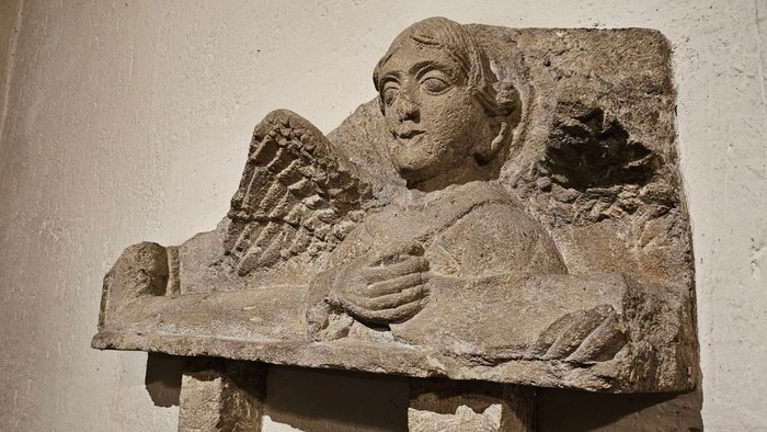 Steinernes Relief eines schlafenden Engels an einer Wand