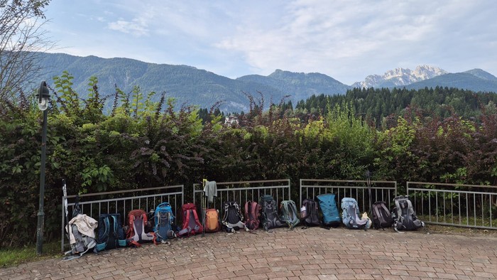 Rucksäcke lehnen an Geländer vor Bergpanorama