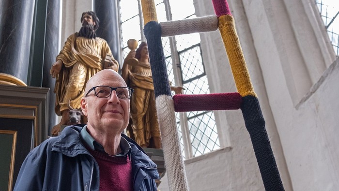 Frau steht vor farbenfroher Treppe in Kirche