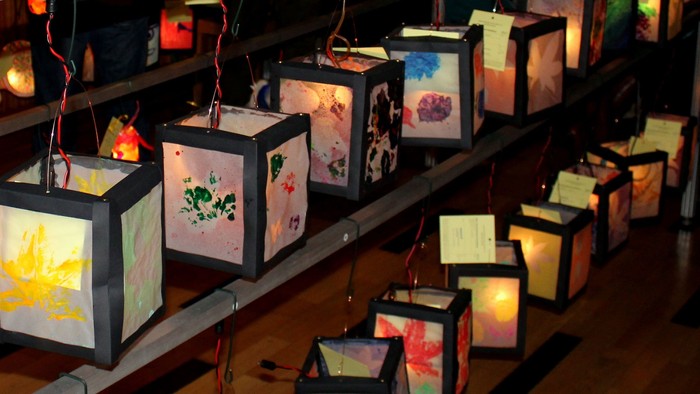 Viele bunte Laternen hängen in einem Raum