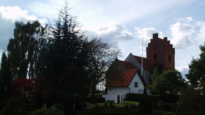 Billedet viser en kirke med et maleri af en folkemængde og et træ.