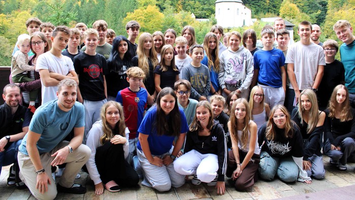 Eine große Gruppe von Jugendlichen posiert für ein Gruppenfoto im Freien