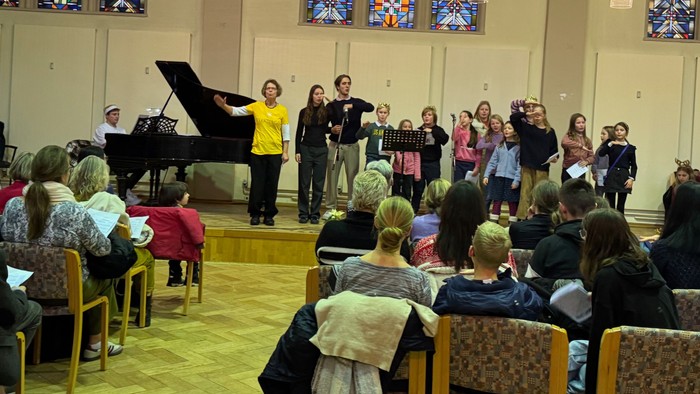 Eine Gruppe von Menschen singt und spielt in einer Kirche, während ein Publikum zusieht.