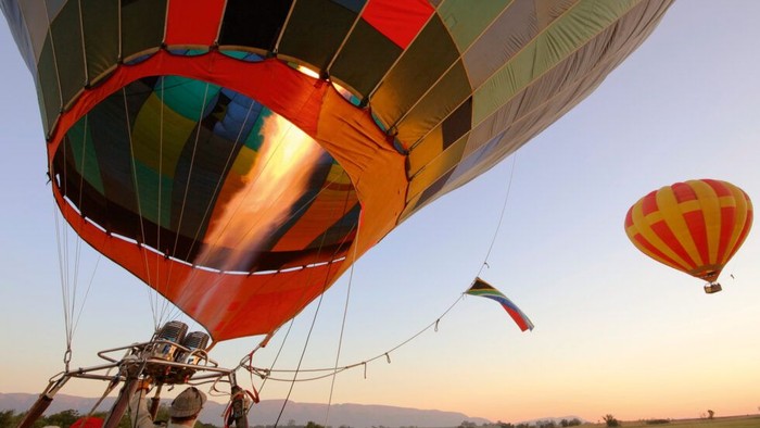 Zwei Heißluftballons beim Start im Sonnenuntergang