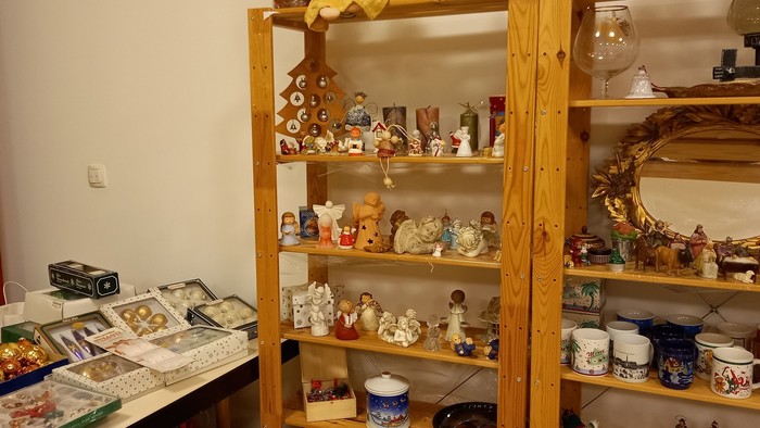Viele kleine Nippes-Artikel auf Regalen und Tisch in einem Raum
