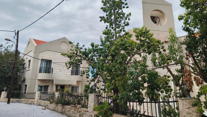 Moderne bygning med klokketårn og grønne områder.