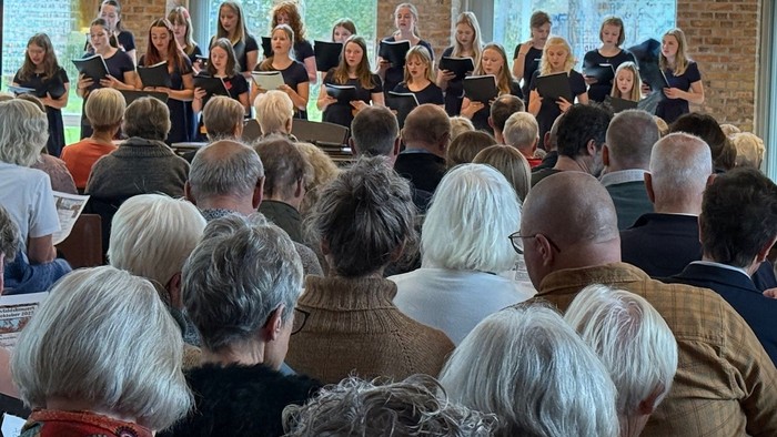 Et kor optræder foran et opmærksomt publikum.