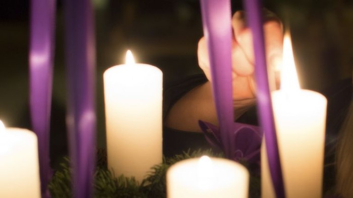 En ung pige ser træt ud mellem lysende lysstaker og violette bælter.