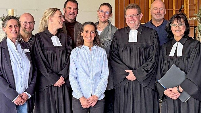 Katrin Gerlach ist in der Mitte des Bildes zu sehen. Um sie herum stehen Kolleginnen und Kollegen, drei davon im Talar.