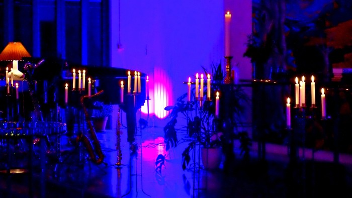 En mørk og mystisk bynattscene med lysende lygter og en lyset kæmpe.