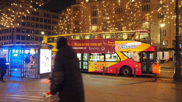 Abendstimmung in der Stadt mit beleuchteten Gebäuden und einem Doppeldeckerbus