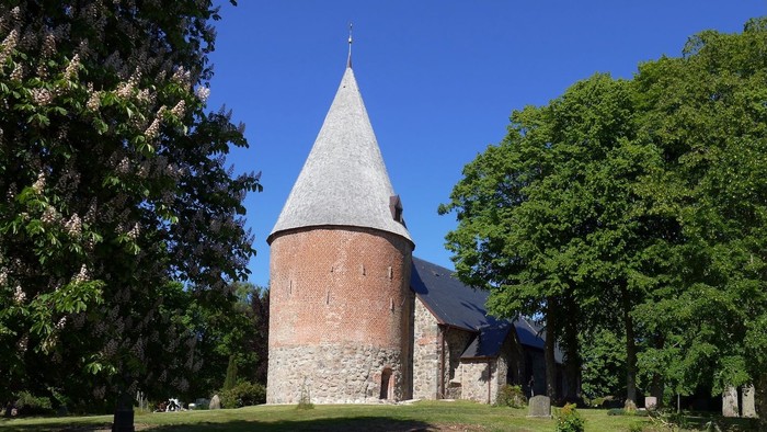 Die Koseler Kirche mit Blick auf den Turm mit Bäumen links und rechts