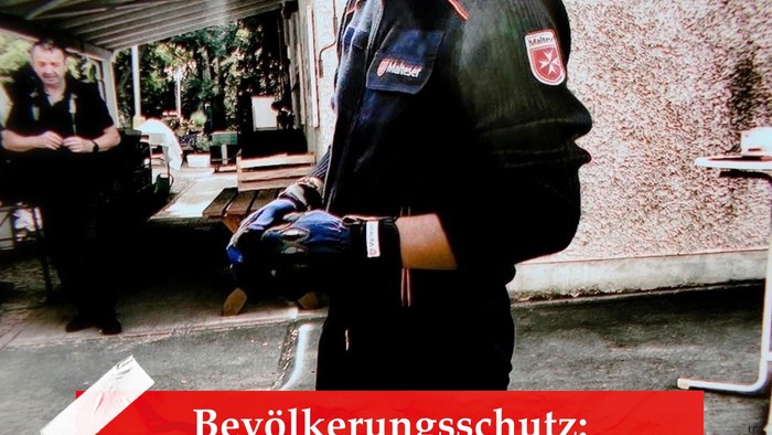 Polizist in Uniform mit einer Waffe in der Hand, mit deutschem Text