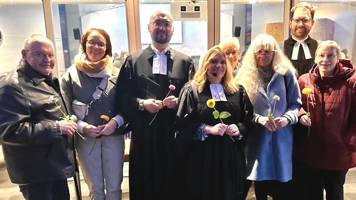 Gruppe von Menschen in formeller Kleidung, die gemeinsam posieren