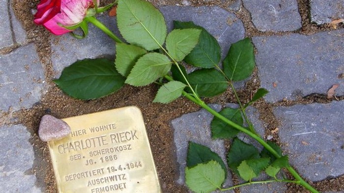 Eine Rose liegt auf einem Gedenkstein für Charlotte Rieck.