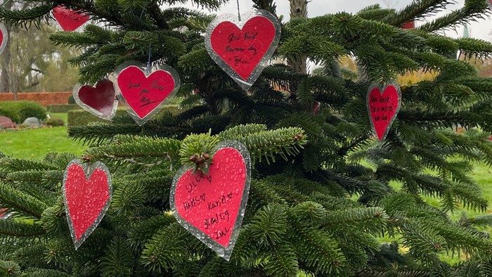 En juletræ dekoreret med røde hjerteformede pynt.