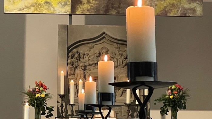 Kerzen und Blumen auf einem Kaminsims arrangiert