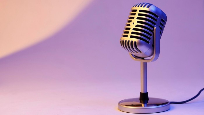 Ein Mikrofon auf einem Ständer vor lila Hintergrund