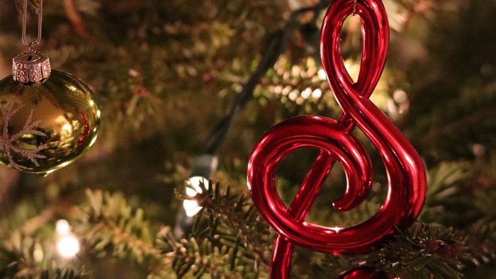 Ein Weihnachtsbaum mit einem roten Notenzeichen-Schmuckstück und einer goldenen Kugel.