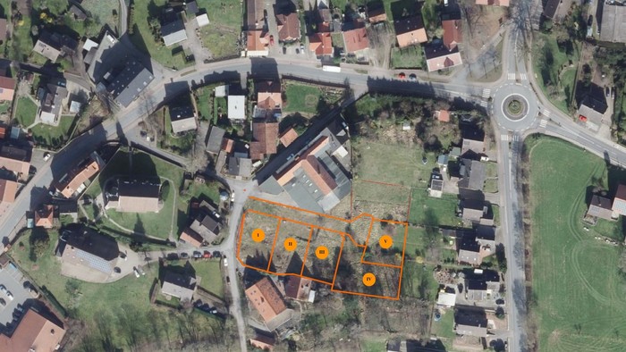 Ein Luftbild des Orts Holzhausen mit den mit orangen Umrissen beschriebenen Baugrundstücken