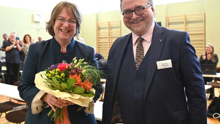 Ein Mann und eine Frau stehen nebeneinander, die Frau hält einen Blumenstrauß