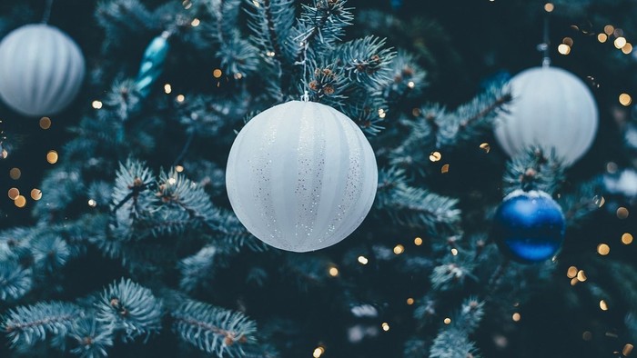 Christmas tree decorated with white and blue ornaments and lights.