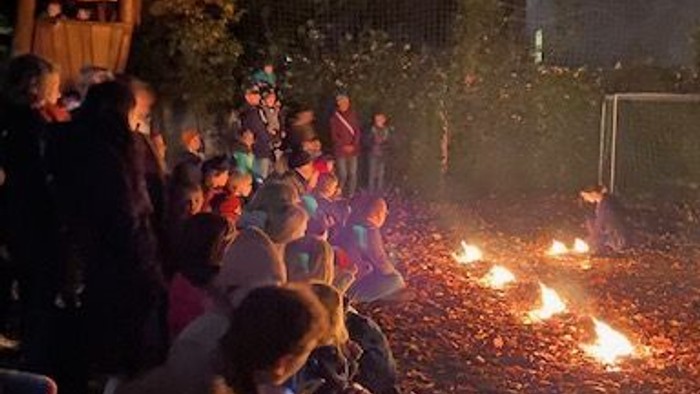 Menschen versammeln sich nachts um ein Feuer in einem Park.