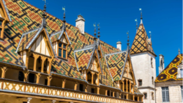 Bunte Ziegeldächer und Türmchen unter blauem Himmel