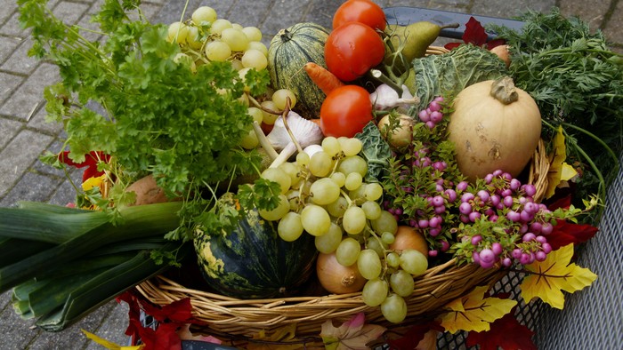 Korb mit frischem Gemüse und Obst auf einem Tisch