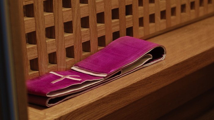 Ein rosa Handtuch liegt auf einer hölzernen Bank mit Gittermuster.