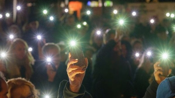 Menschen setzen mit Lichtern ein Zeichen für Frieden und Verständigung.