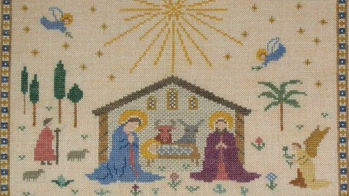 Billedet viser en stitched julekort med en nativity scene og himmelske figurer.