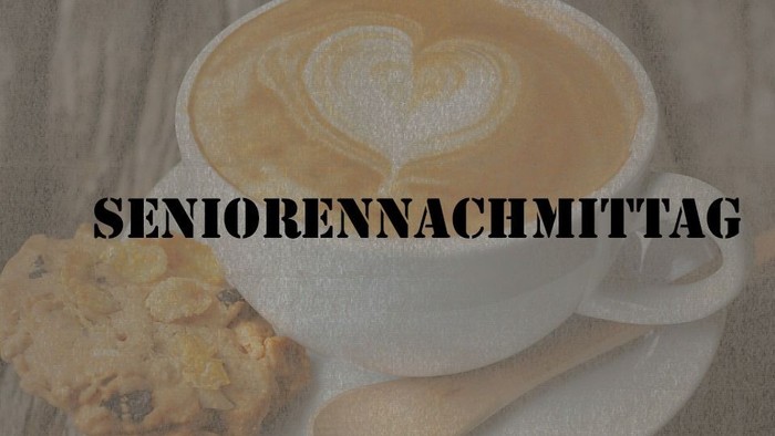 Ein Latte Macchiato mit Herzverzierung und ein Keks auf einem Teller