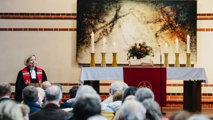 Eine Pfarrerin predigt zu Menschen