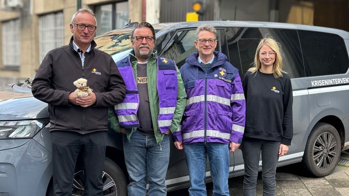 Vier Notfallseelsorgende vor dem Fahrzeug, Olaf Schaper mit dem Luca-Bären in den Händen, Ehrenamtlicher Mike van Hauten, Diakon Gregor Hergarten und Ehrenamtliche Lara Seemann.