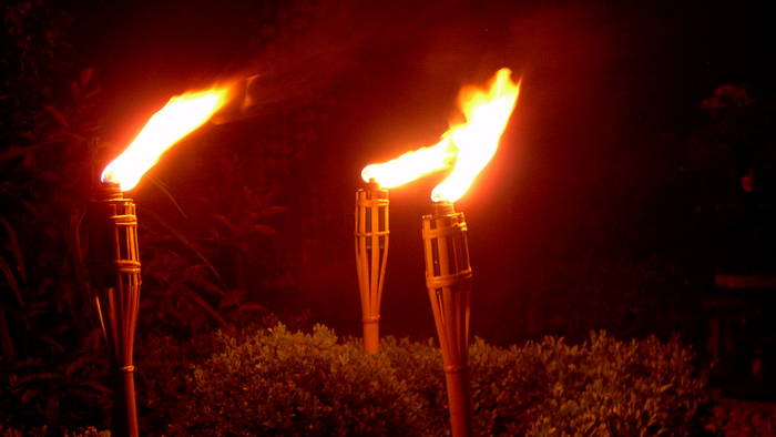 Tre flammende fackler i mørke omgivelser